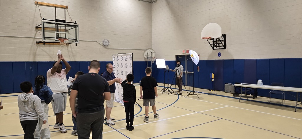 Students waiting to have their photos taken in gym