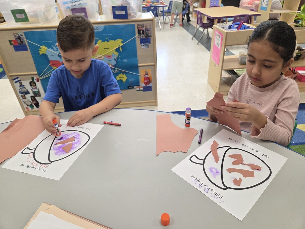 child gluing paper to an acorn paper