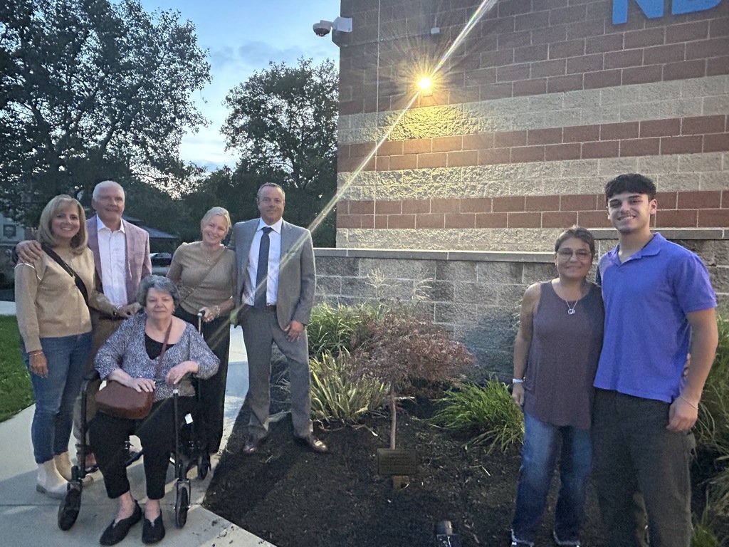 Group of people standing in front of memorial plaque