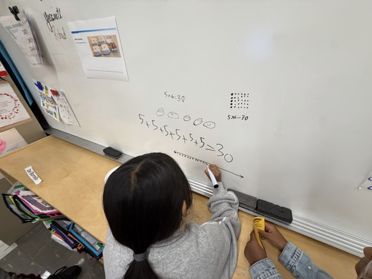 Student working on white board as part of thinking classroom 