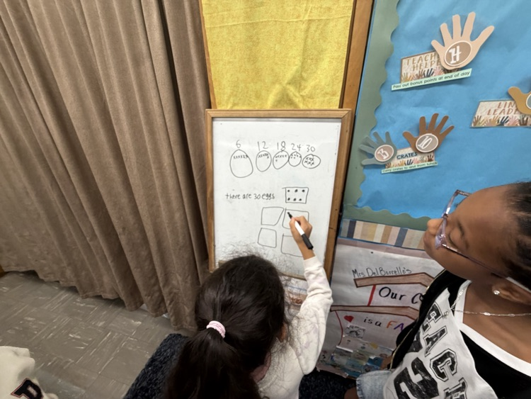 Students working together on easel as part of thinking classroom 
