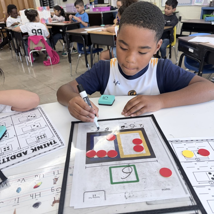 Student practicing math with counters and marker