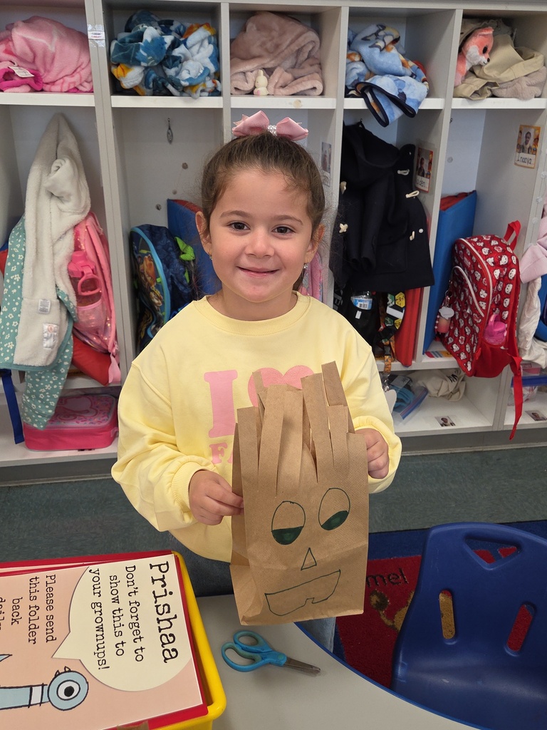 student cutting paper bag into monsters