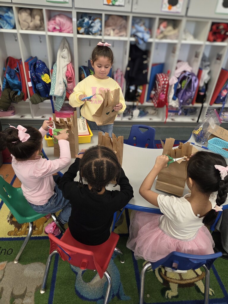 students cutting paper bag into monsters
