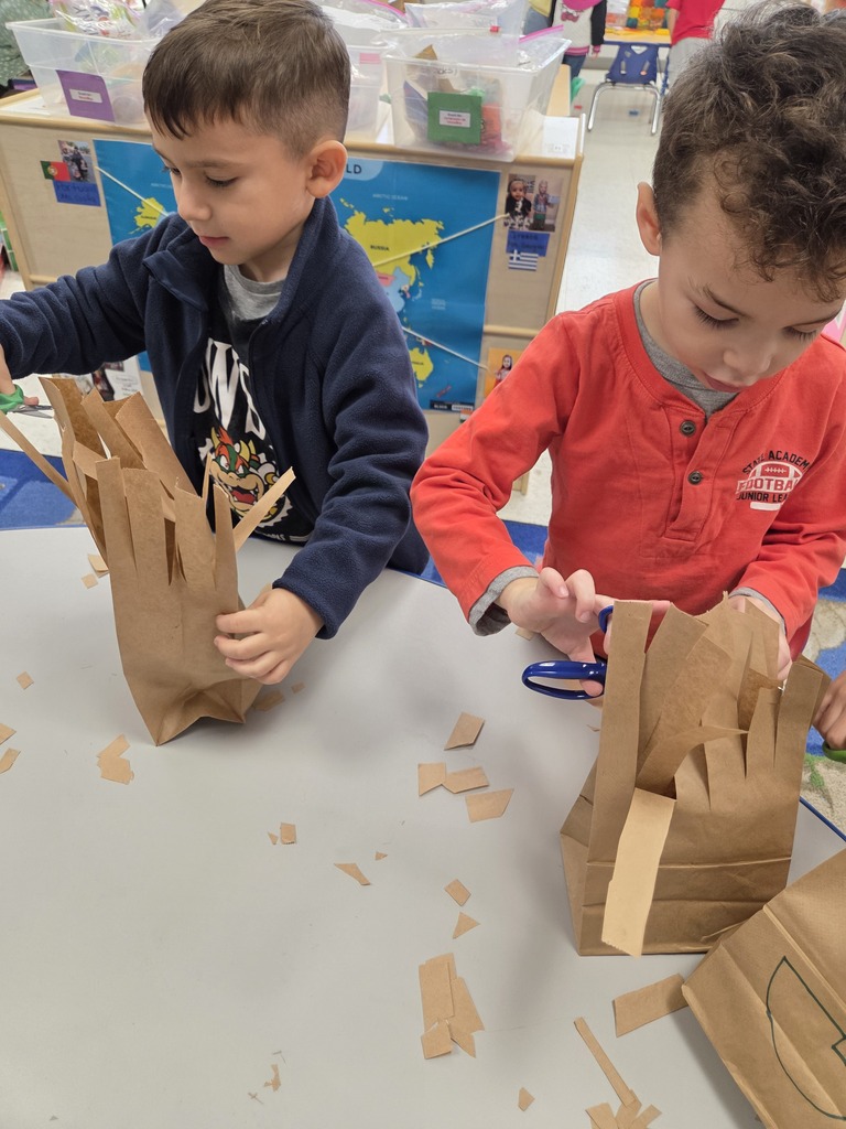 student cutting paper bag into monsters