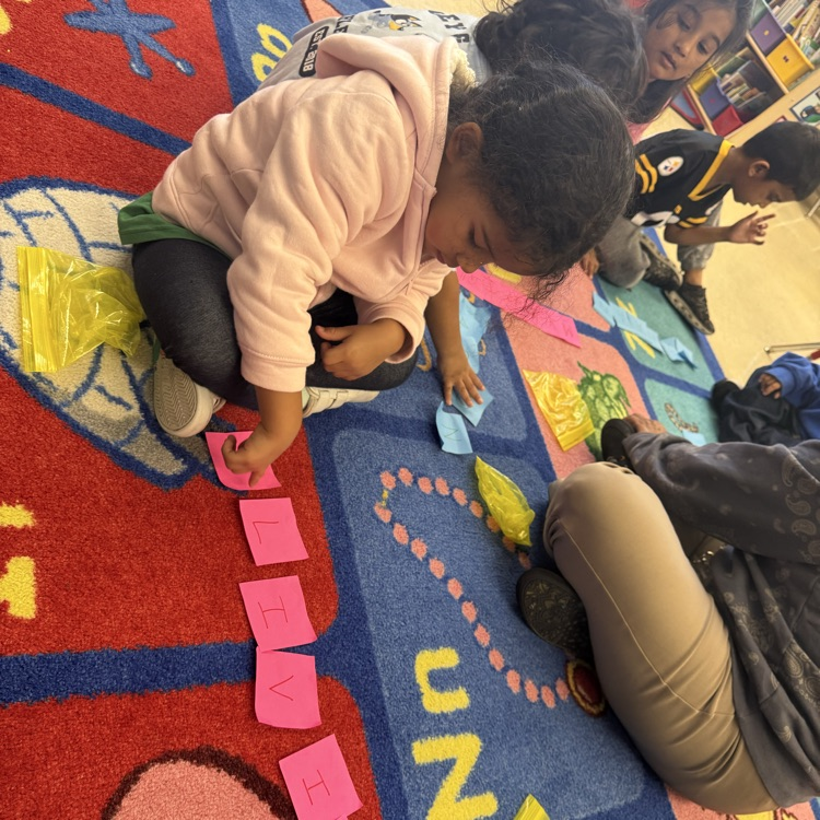 Students learning together on the carpet with post its