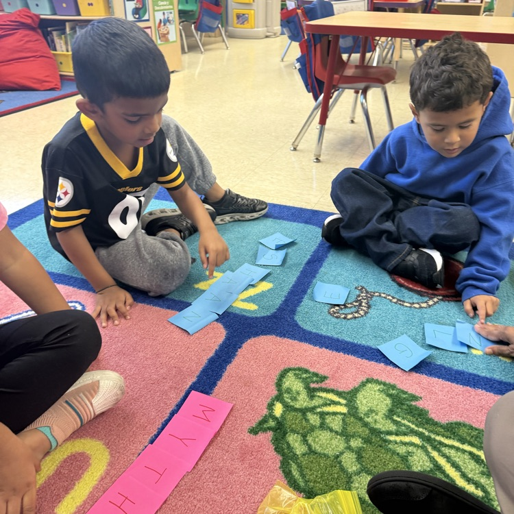 Students learning together on the carpet with post its