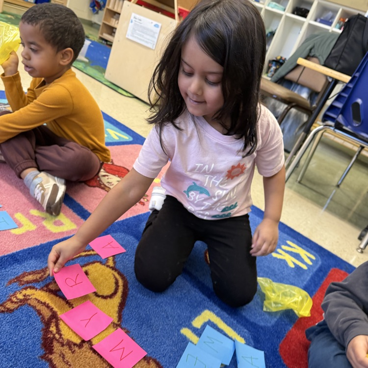 Students learning together on the carpet with post its