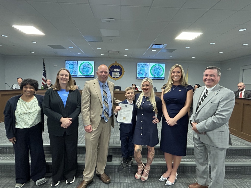 Student being recognized by board of education members