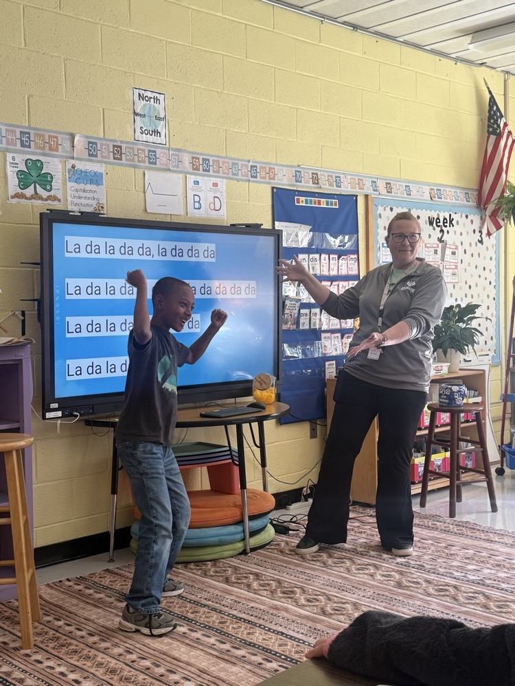 Student dancing in front of class next to a teacher