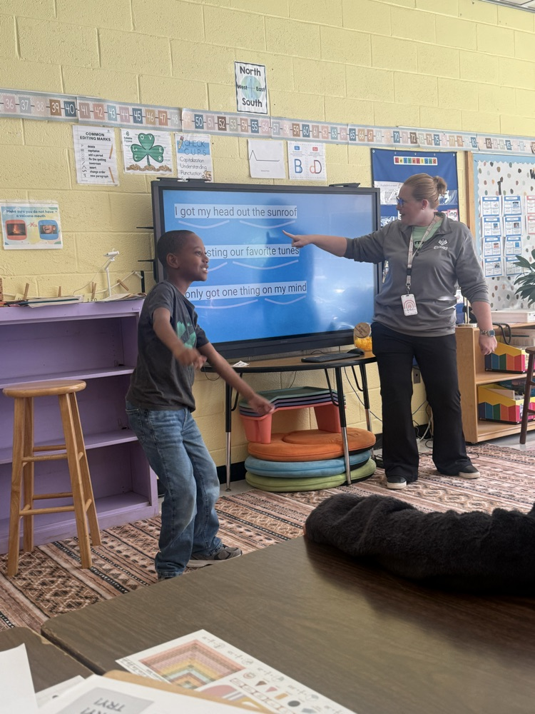 Student dancing in front of class next to a teacher