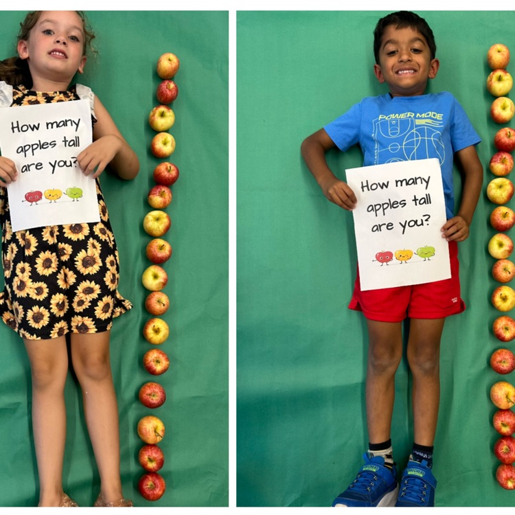 Kids laying next to a stack of apples