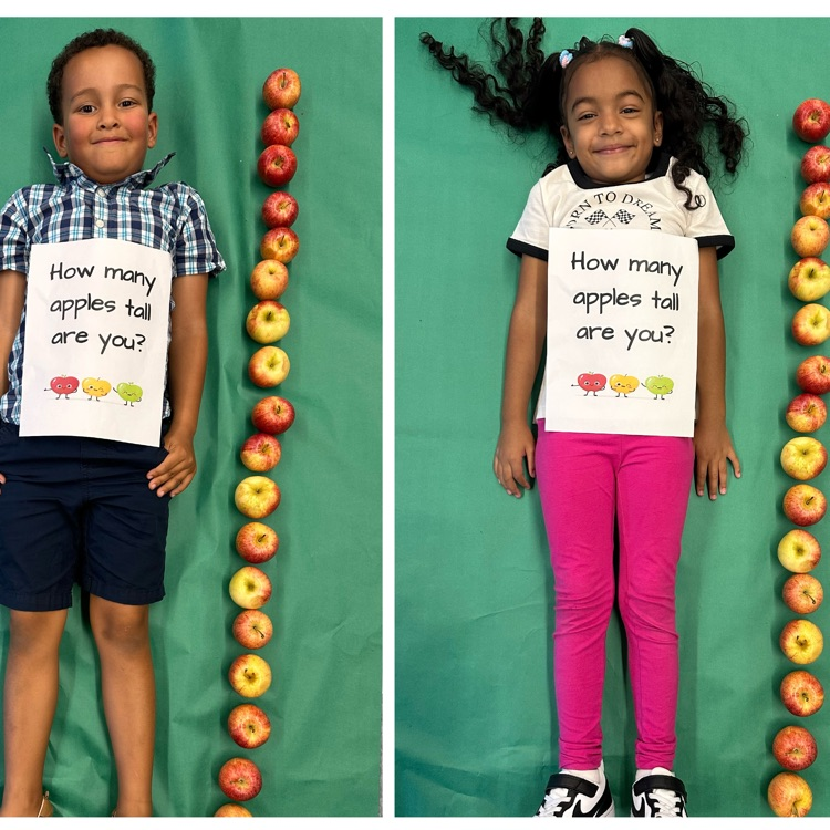 Kids laying next to a stack of apples