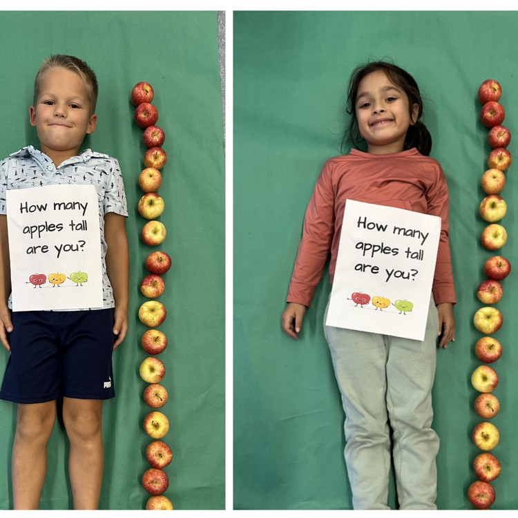 Kids laying next to a stack of apples