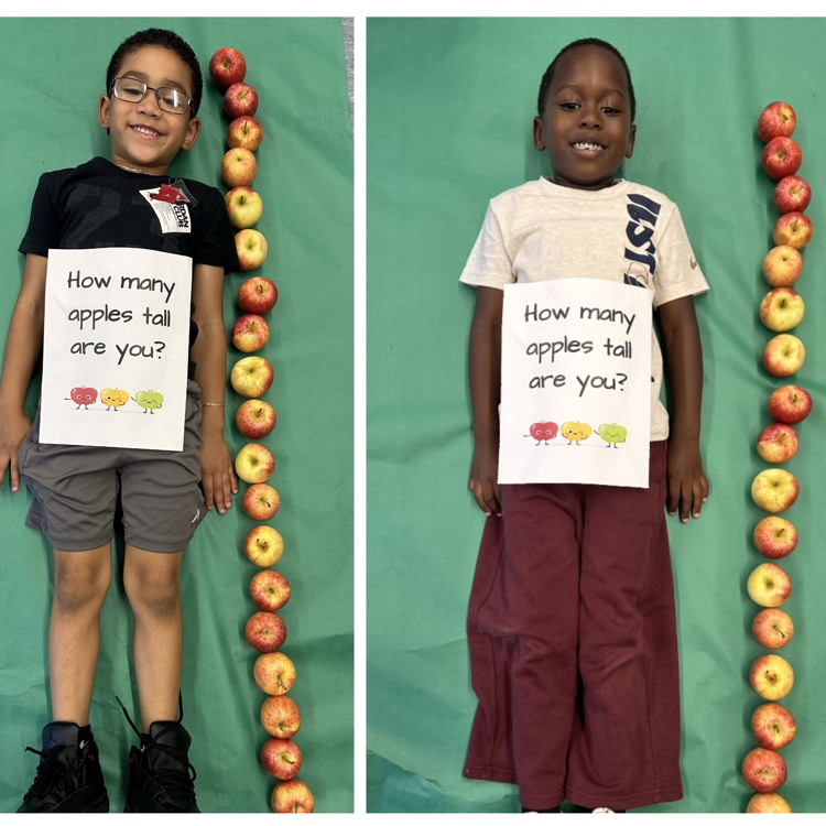 Kids laying next to a stack of apples