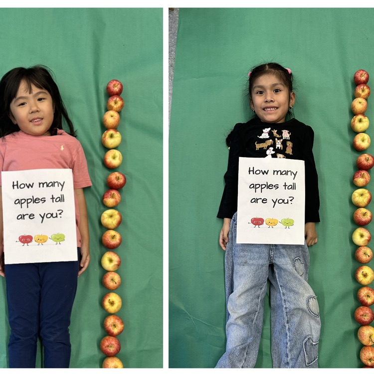 Kids laying next to a stack of apples
