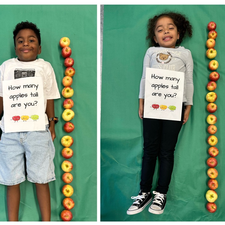 Kids laying next to a stack of apples