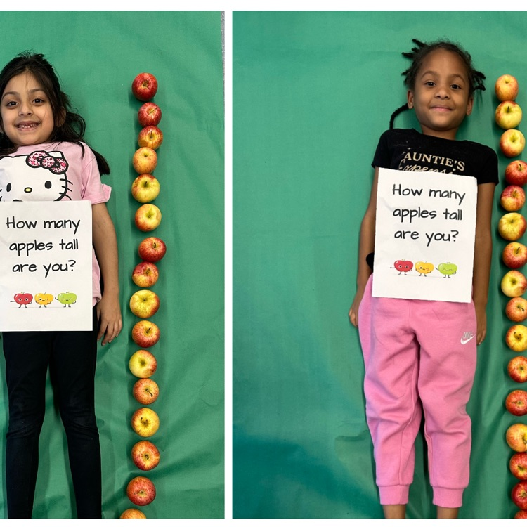 Kids laying next to a stack of apples