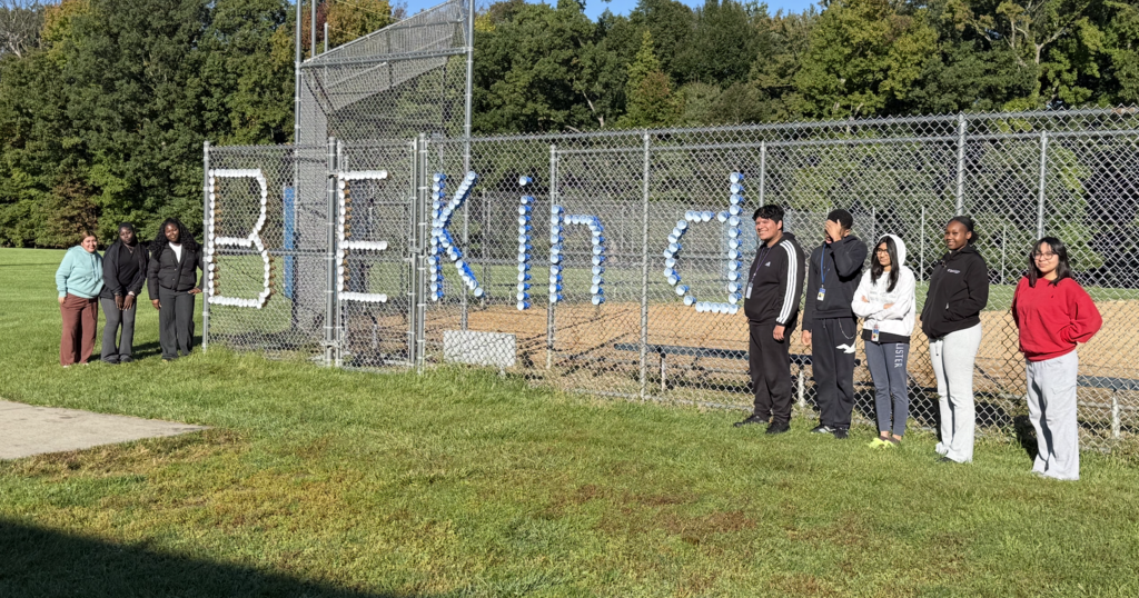 Be Kind spelled out in fence with students nearby