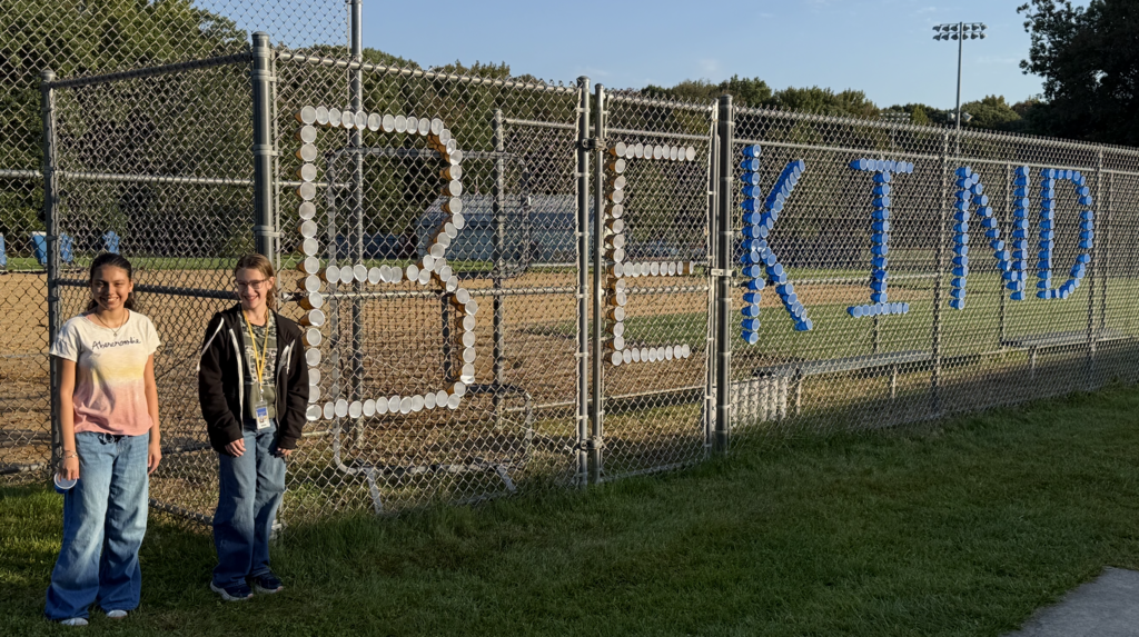 Be Kind spelled out in fence with students nearby
