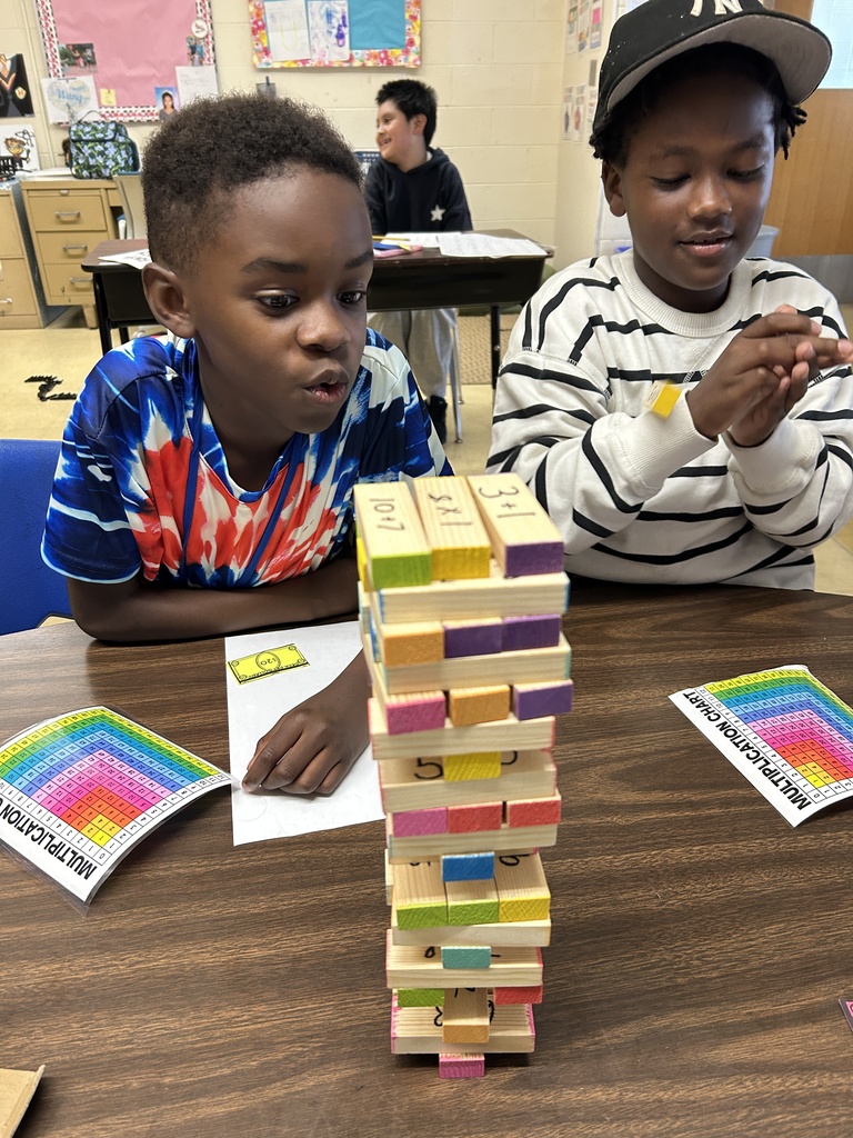 Two students practice multiplication facts by playing Jenga