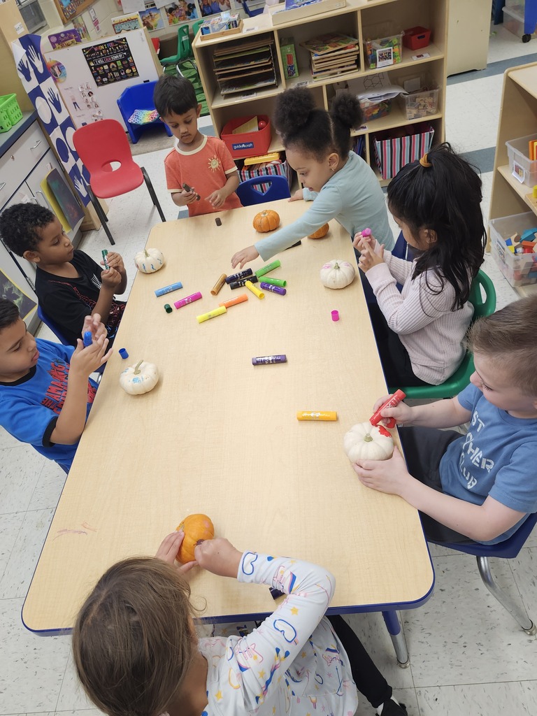 Students sitting at a table doing a Pumpkin coloring activity