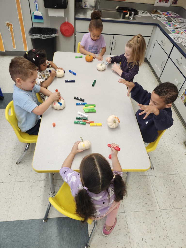 Students sitting at a table doing a Pumpkin coloring activity