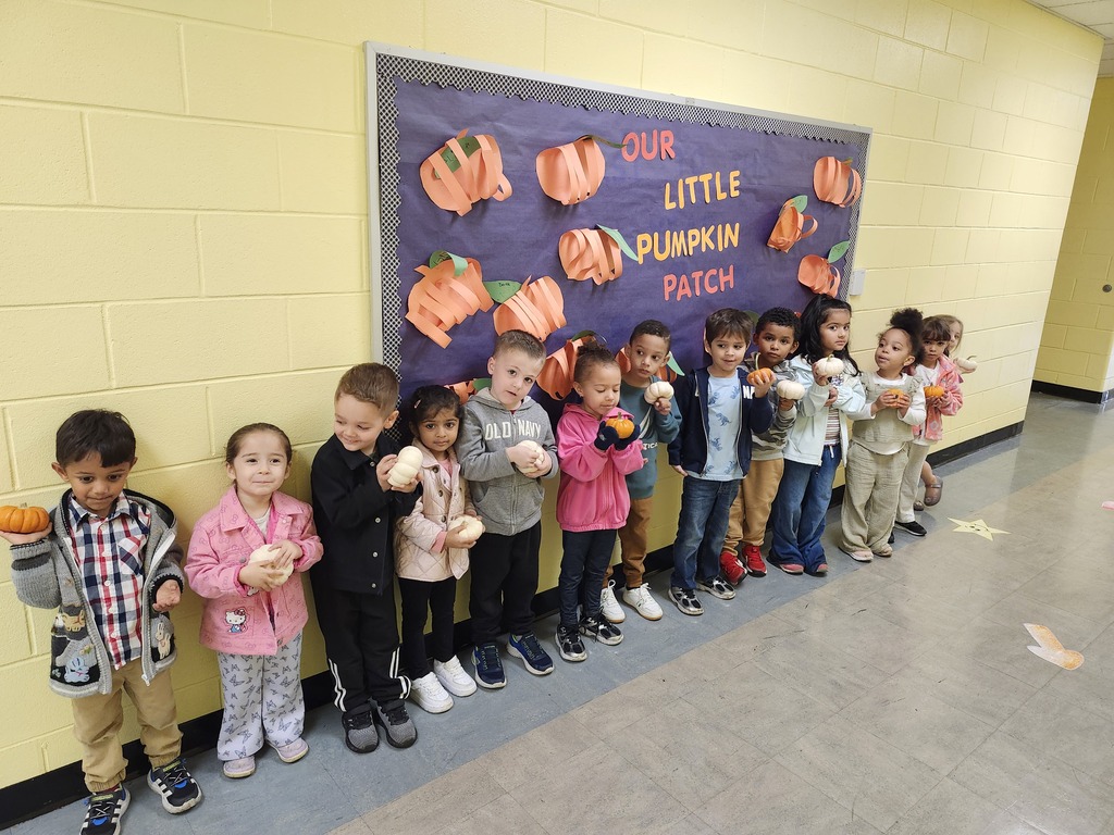 Students lined up in the hallway with their pumpkins