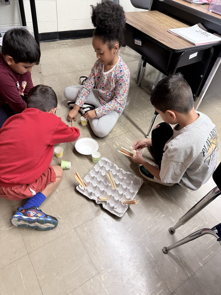 Students counting popsicle sticks into egg crates