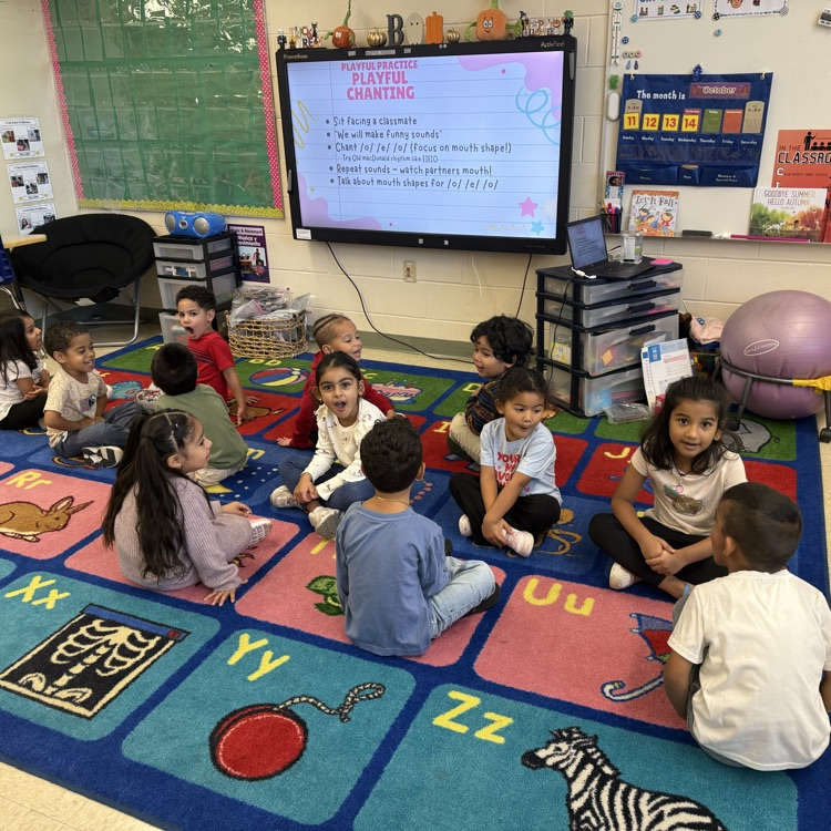 Students talking to each other on a classroom carpet