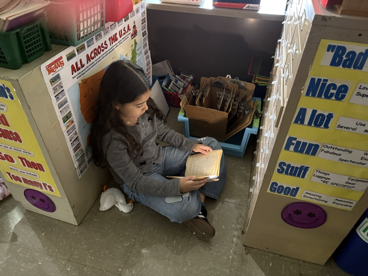 Student reading book with flashlight