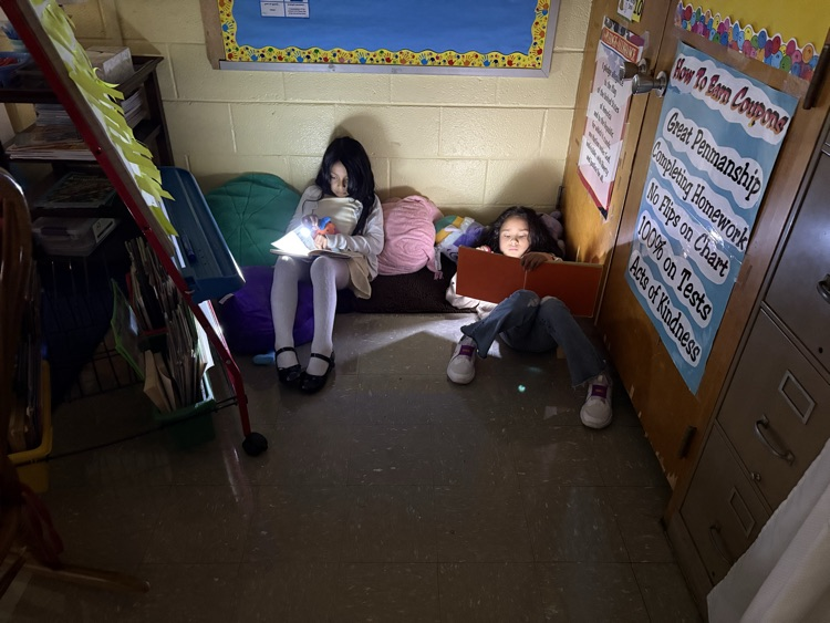 Students reading book with flashlight