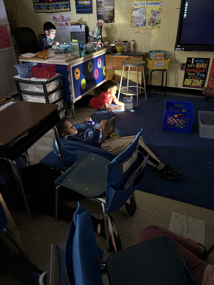 Students reading book with flashlight