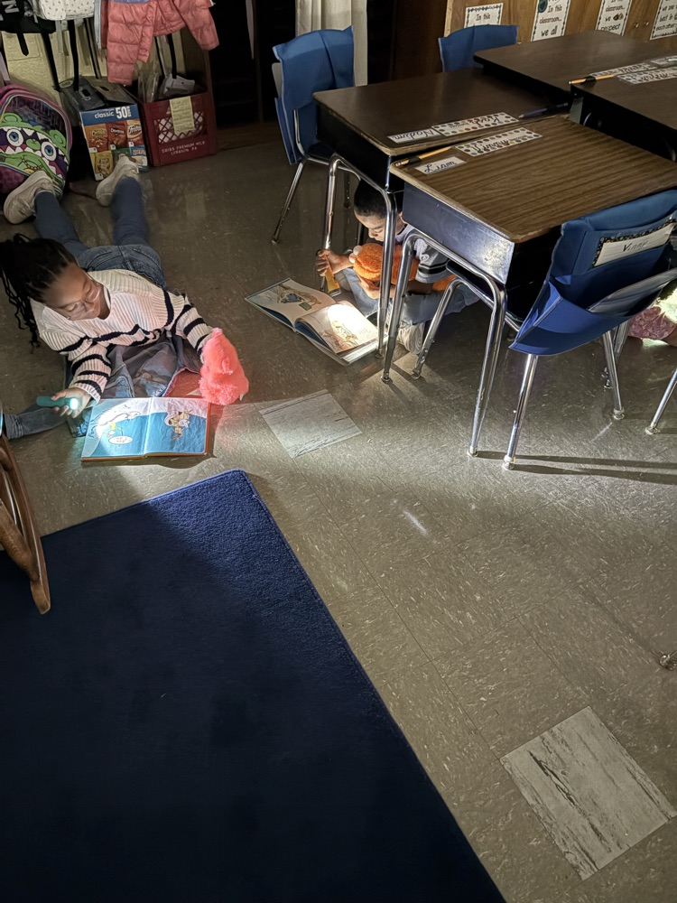 Student reading book with flashlight