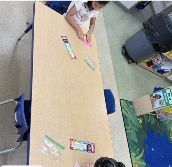 Students practicing with small letter cards at a table