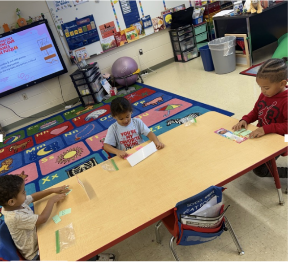 Students practicing with small letter cards at a table