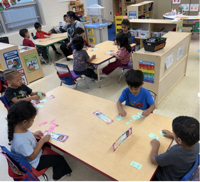 Students practicing with small letter cards at a table