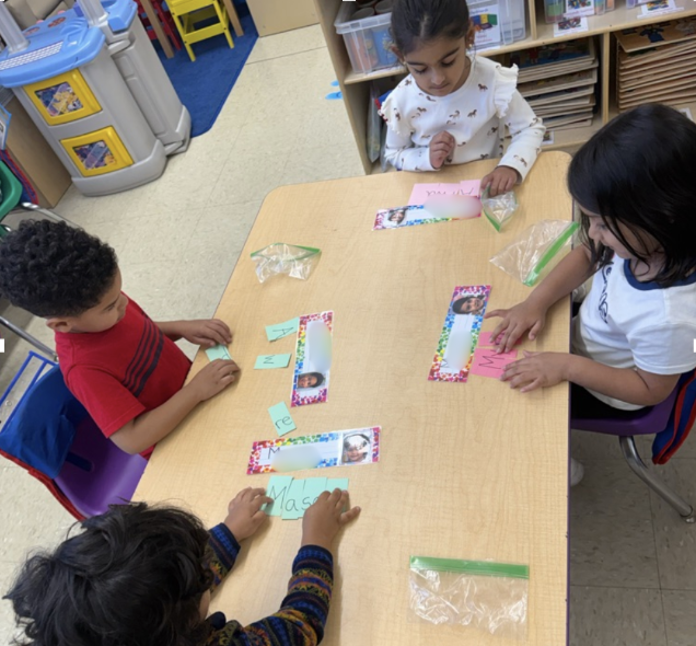 Students practicing with small letter cards at a table