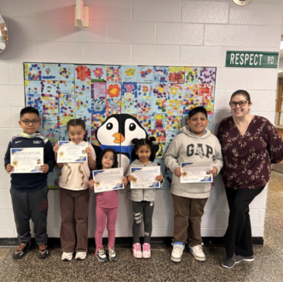 Students standing with certificates with their principal