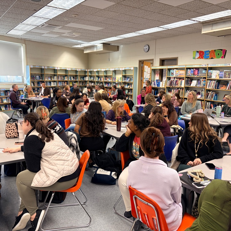 Staff sitting at tables for faculty meeting 