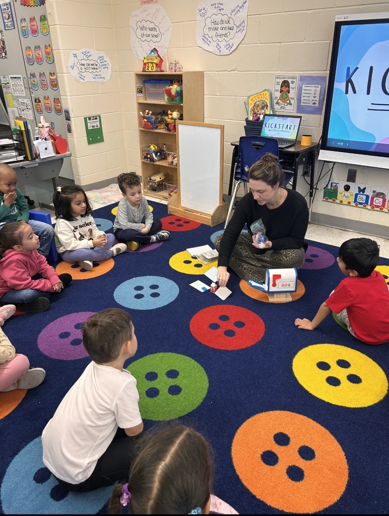 Students sitting on classroom carpet around teacher