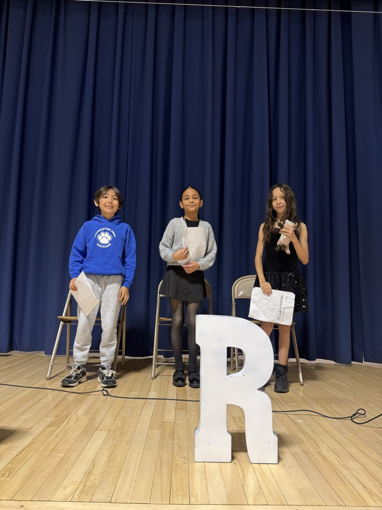 Students standing on stage with speeches in their hands