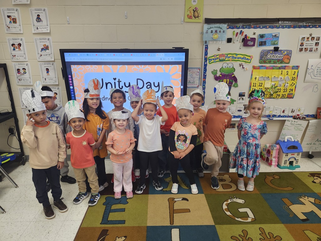 Class photo in a classroom with students wearing orange for Unity Day 