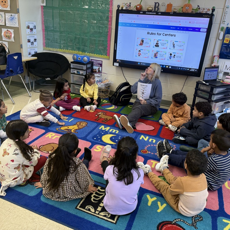 Students sitting on classroom carpet around teacher