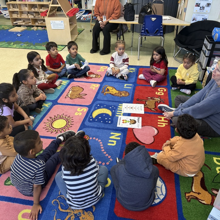 Students sitting on classroom carpet around teacher