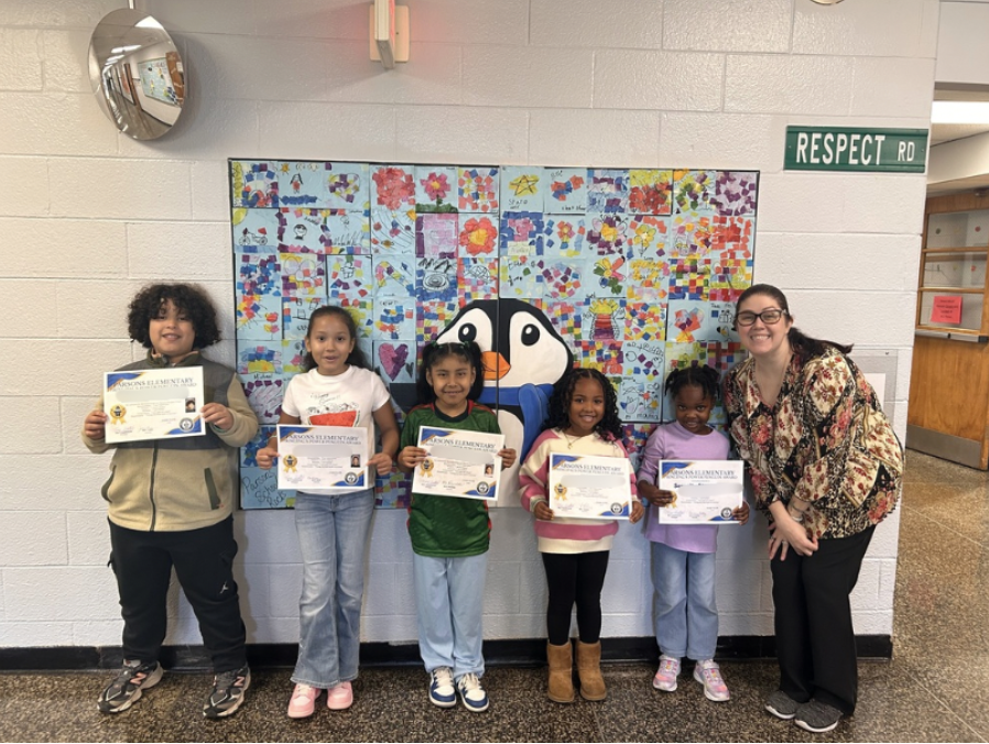 Students standing with certificates with their principal
