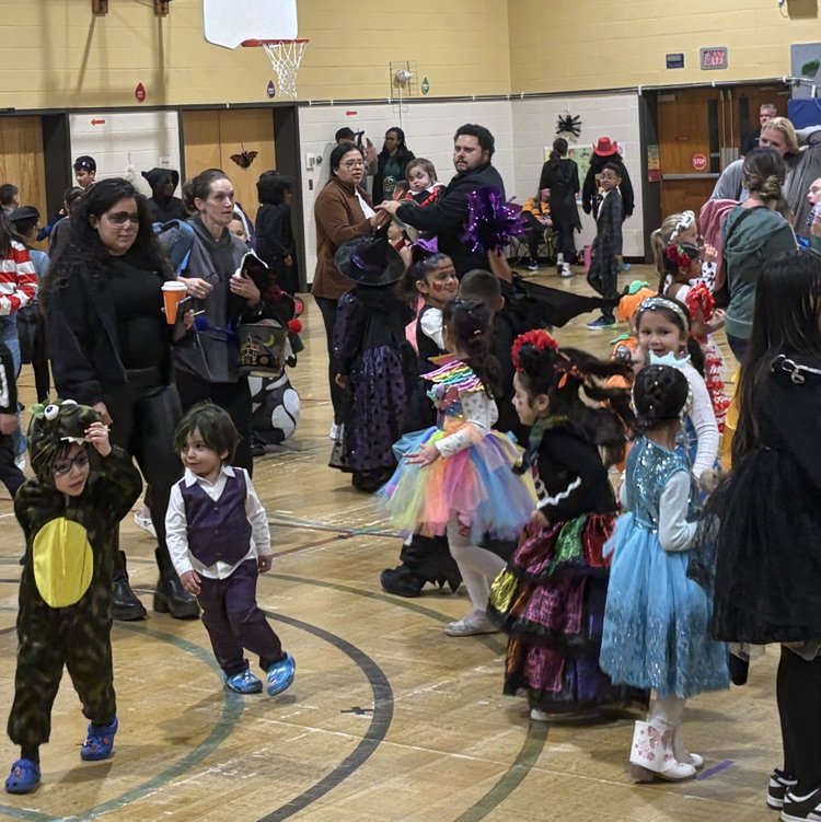 Students and parents at halloween event in gymnasium
