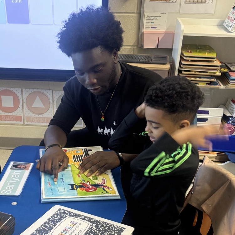 High school student helping a little kid read