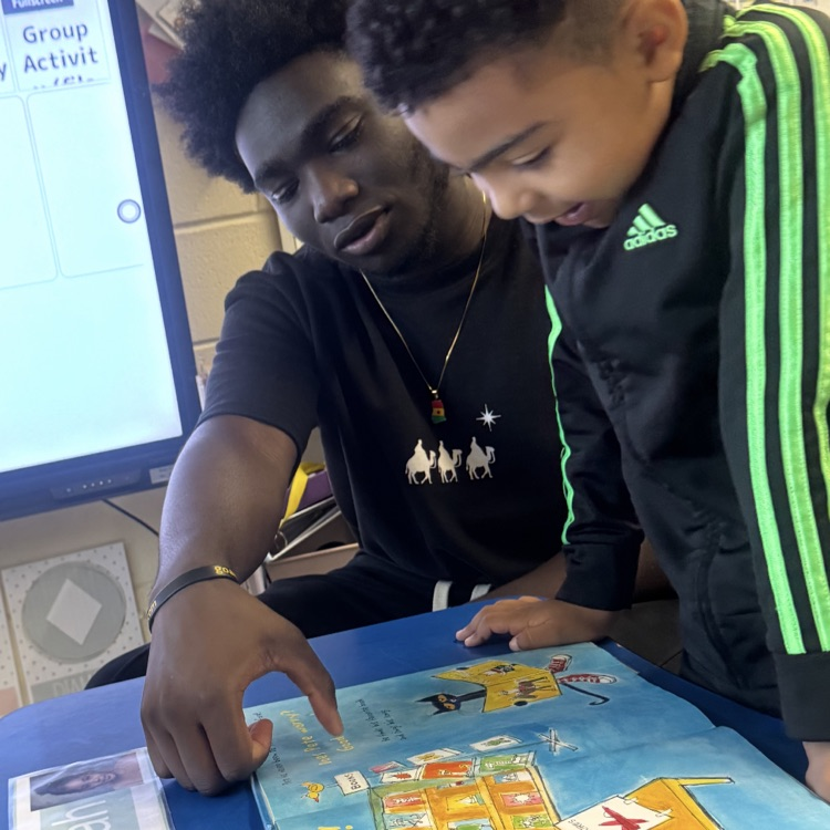 High school student helping a little kid read