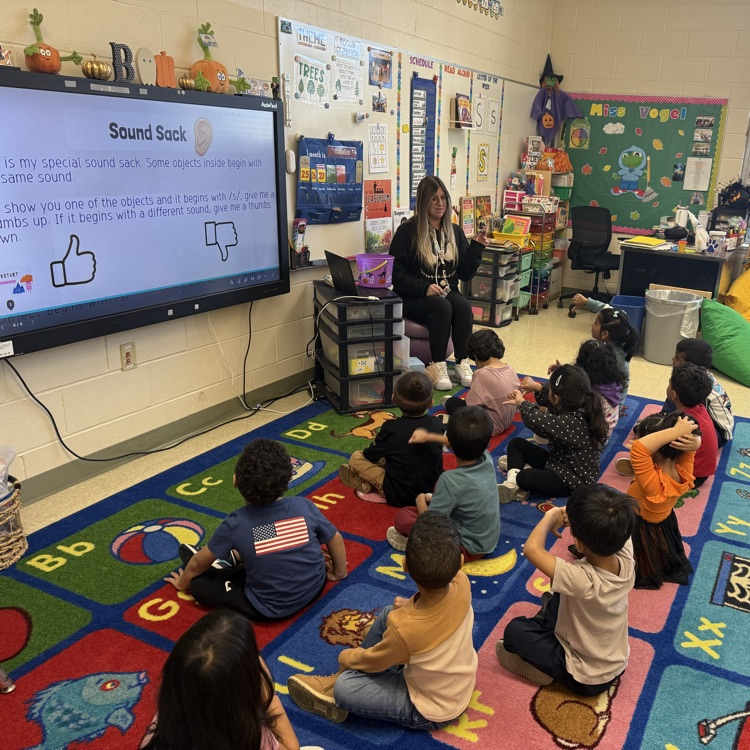 Students listening to a lesson on the classroom carpet
